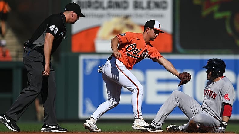 Aug 20, 2022; Baltimore, Maryland, USA; Boston Red Sox designated hitter J.D. Martinez (28) leans back to avoid Baltimore Orioles second baseman Ramon Urias (29) tag for a second inning double at Oriole Park at Camden Yards. Mandatory Credit: Tommy Gilligan-USA TODAY Sports