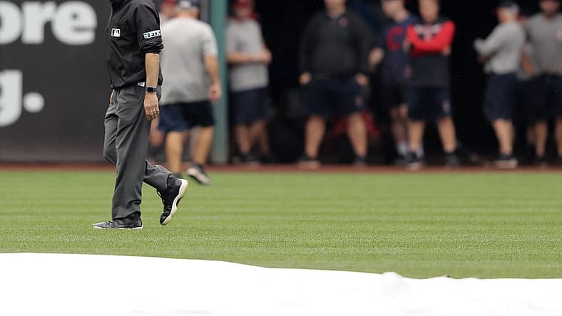 Aug 21, 2022; Cleveland, Ohio, USA; Umpire David Rackley inspects left field after a heavy rain prior to the start of the Cleveland Guardians and Chicago White Sox game at Progressive Field. Mandatory Credit: Aaron Josefczyk-USA TODAY Sports