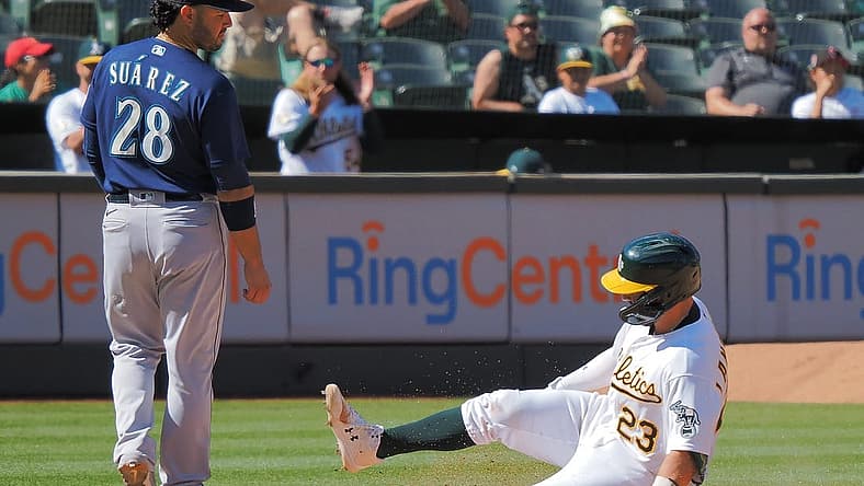 Aug 21, 2022; Oakland, California, USA; Oakland Athletics catcher Shea Langeliers (23) safe at third base below Seattle Mariners third baseman Eugenio Suarez (28) during the eighth inning at RingCentral Coliseum. Mandatory Credit: Kelley L Cox-USA TODAY Sports