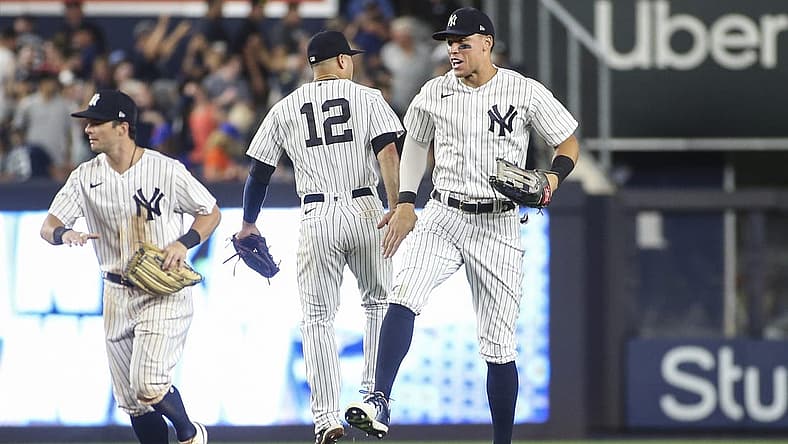 Aug 22, 2022; Bronx, New York, USA; New York Yankees shortstop Isiah Kiner-Falefa (12) and center fielder Aaron Judge (99) celebrate after defeating the New York Mets 4-2 at Yankee Stadium. Mandatory Credit: Wendell Cruz-USA TODAY Sports