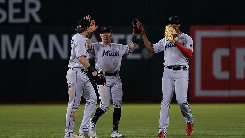 Aug 22, 2022; Oakland, California, USA; (l to r) Miami Marlins left fielder JJ Bleday (67) and center fielder Peyton Burdick (86) and right fielder Jerar Encarnacion (64) celebrate after defeating the Oakland Athletics at RingCentral Coliseum. Mandatory Credit: Stan Szeto-USA TODAY Sports