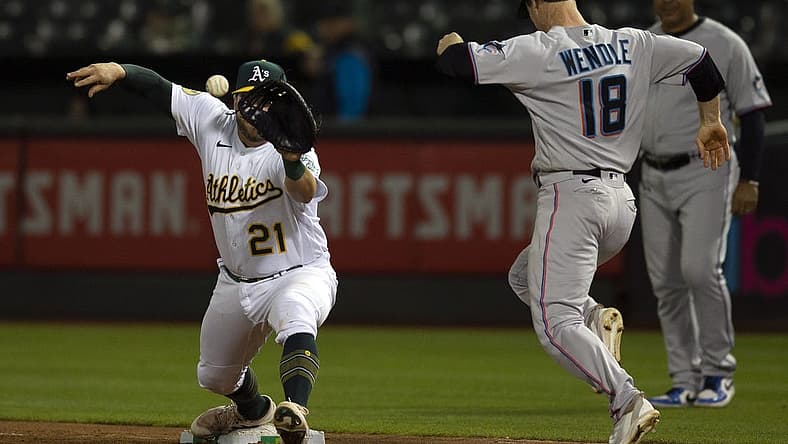Aug 23, 2022; Oakland, California, USA; Oakland Athletics first baseman Stephen Vogt (21) takes the throw at first to force out Miami Marlins third baseman Joey Wendle (18) during the sixth inning at RingCentral Coliseum. Mandatory Credit: D. Ross Cameron-USA TODAY Sports