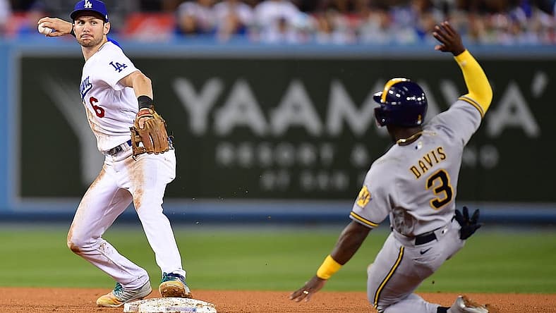 Aug 23, 2022; Los Angeles, California, USA; Milwaukee Brewers center fielder Jonathan Davis (3) is out at second as Los Angeles Dodgers shortstop Trea Turner (6) throws to first for the out against left fielder Christian Yelich (22) during the fifth inning at Dodger Stadium. Mandatory Credit: Gary A. Vasquez-USA TODAY Sports