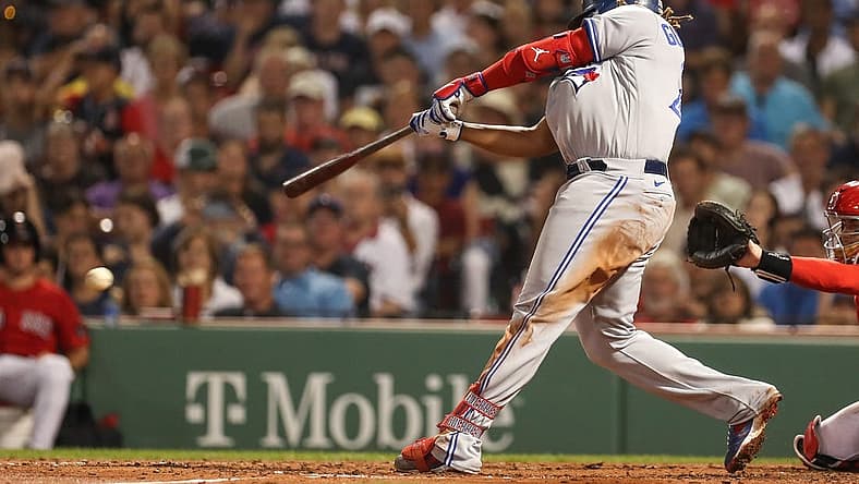Aug 24, 2022; Boston, Massachusetts, USA; Toronto Blue Jays first baseman Vladimir Guerrero (27) hits an RBI during the fifth inning against the Boston Red Sox at Fenway Park. Mandatory Credit: Paul Rutherford-USA TODAY Sports