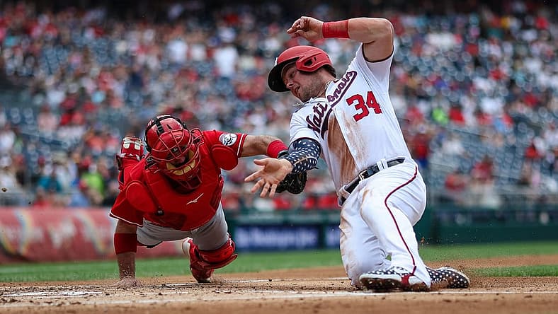 Aug 28, 2022; Washington, District of Columbia, USA; Washington Nationals first baseman Luke Voit (34) is tagged out at home by Cincinnati Reds catcher Austin Romine (28) during the fourth inning at Nationals Park. Mandatory Credit: Scott Taetsch-USA TODAY Sports