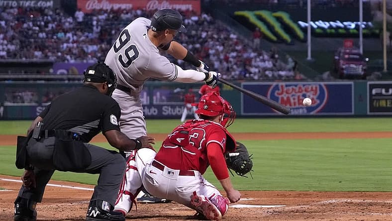 Aug 30, 2022; Anaheim, California, USA; New York Yankees center fielder Aaron Judge (99) bats in the third inning as Los Angeles Angels catcher Max Stassi (33) and home plate umpire Alan Porter watch at Angel Stadium. Mandatory Credit: Kirby Lee-USA TODAY Sports