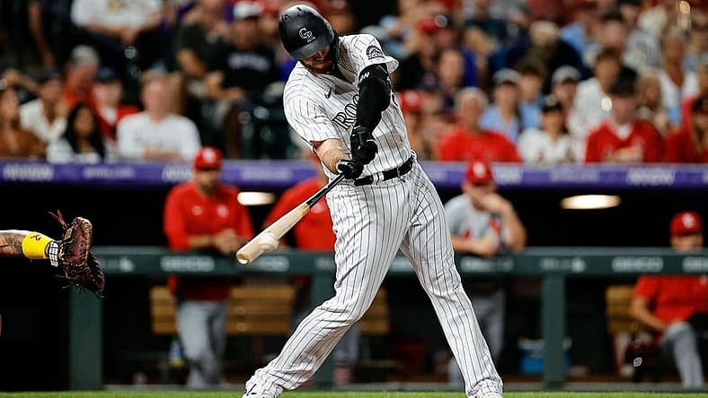 Aug 10, 2022; Denver, Colorado, USA; Colorado Rockies first baseman C.J. Cron (25) hits an RBI triple in the fifth inning against the St. Louis Cardinals at Coors Field. Mandatory Credit: Isaiah J. Downing-USA TODAY Sports