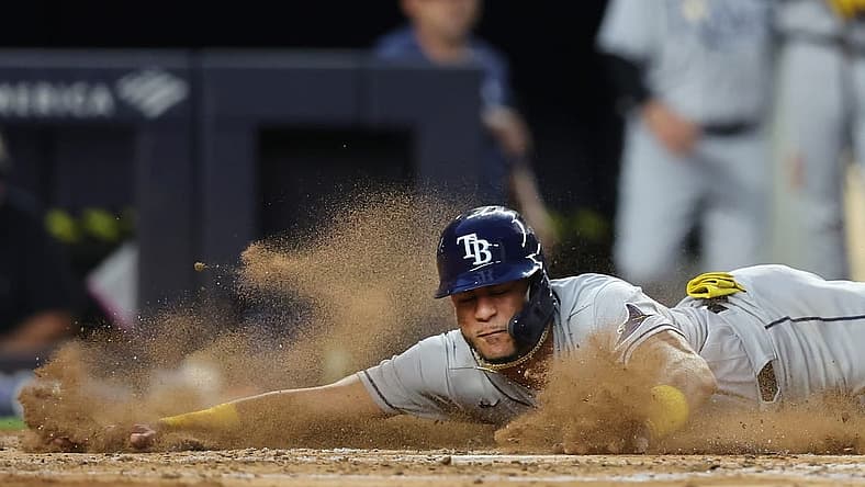 Aug 17, 2022; Bronx, New York, USA; Tampa Bay Rays center fielder Jose Siri (22) slides into home to score a run against the New York Yankees on a double by Rays third baseman Yandy Diaz (not pictured) during the third inning at Yankee Stadium. Mandatory Credit: Brad Penner-USA TODAY Sports