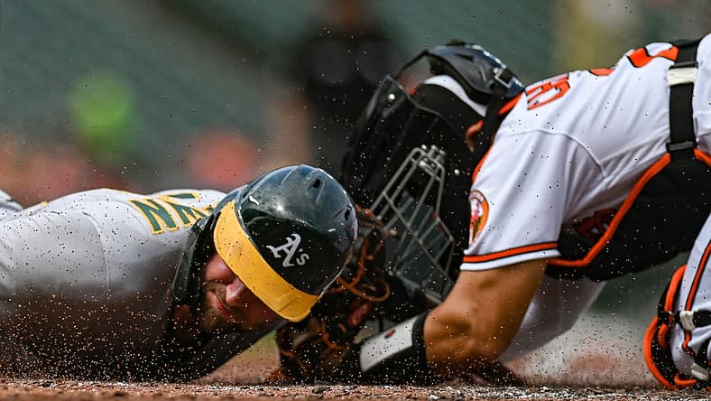 Sep 4, 2022; Baltimore, Maryland, USA; Oakland Athletics first baseman Seth Brown (15) slides past Baltimore Orioles catcher Robinson Chirinos (23) to score during the second inning at Oriole Park at Camden Yards. Mandatory Credit: Tommy Gilligan-USA TODAY Sports