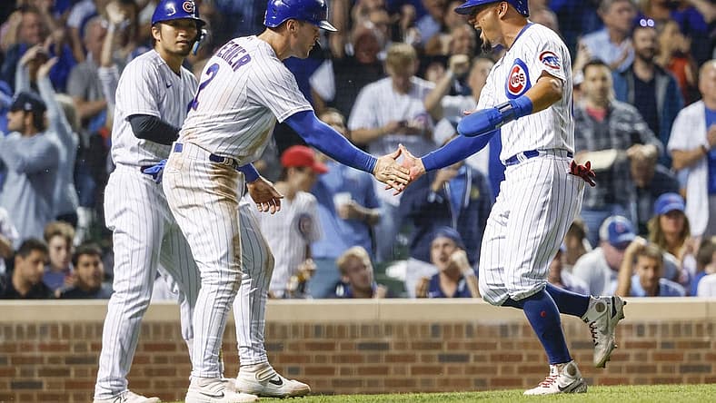 Sep 6, 2022; Chicago, Illinois, USA; Chicago Cubs shortstop Nico Hoerner (2) and center fielder Rafael Ortega (66) celebrate after they both scored against the Cincinnati Reds during the sixth inning at Wrigley Field. Mandatory Credit: Kamil Krzaczynski-USA TODAY Sports