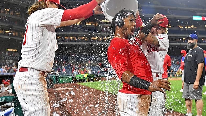 Sep 6, 2022; Philadelphia, Pennsylvania, USA; Philadelphia Phillies second baseman Jean Segura (2) has water dumped on by third baseman Alec Bohm (28) and shortstop Bryson Stott (5) after hitting a walk-off RBU single during the ninth inning against the Miami Marlins at Citizens Bank Park. Mandatory Credit: Eric Hartline-USA TODAY Sports