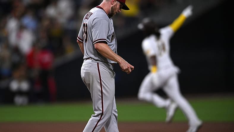Sep 6, 2022; San Diego, California, USA; San Diego Padres designated hitter Josh Bell (right) gestures while rounding the bases after hitting a home run against Arizona Diamondbacks starting pitcher Merrill Kelly (29) during the seventh inning at Petco Park. Mandatory Credit: Orlando Ramirez-USA TODAY Sports