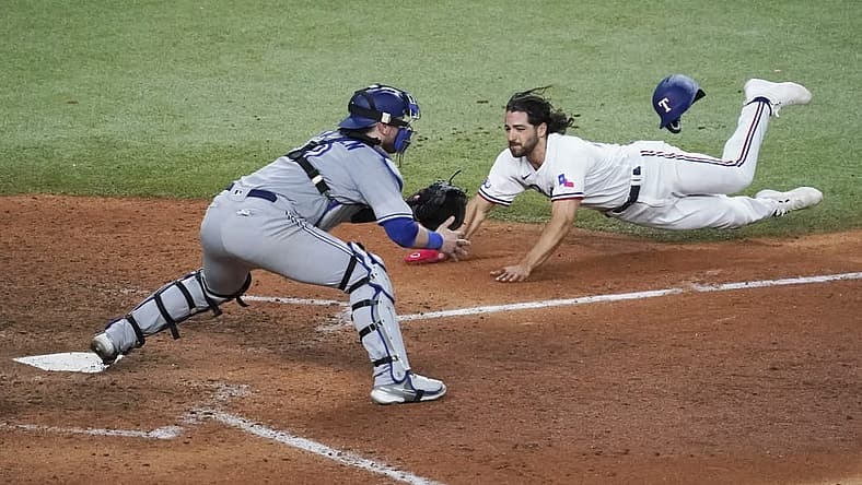 Sep 10, 2022; Arlington, Texas, USA; Texas Rangers third baseman Josh Smith (47) dives into home plate as Toronto Blue Jays catcher Danny Jansen (9) awaits the throw during the sixth inning at Globe Life Field. Mandatory Credit: Raymond Carlin III-USA TODAY Sports