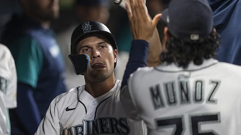 Sep 10, 2022; Seattle, Washington, USA; Seattle Mariners second baseman Adam Frazier (26) is congrulated by teammates in the dugout after scoring a run during the seventh inning against the Atlanta Braves at T-Mobile Park. Mandatory Credit: Stephen Brashear-USA TODAY Sports