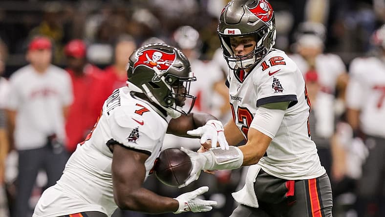 Sep 18, 2022; New Orleans, Louisiana, USA; Tampa Bay Buccaneers quarterback Tom Brady (12) hands the ball off to running back Leonard Fournette (7) against the New Orleans Saints during the first half at Caesars Superdome. Mandatory Credit: Stephen Lew-USA TODAY Sports