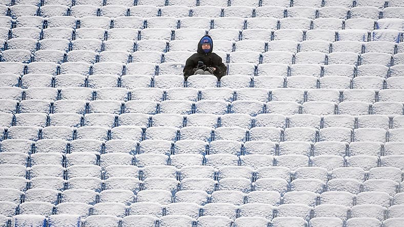 Jan 2, 2022; Orchard Park, New York, USA; A fan sits in the snow covered stands prior to the game between the Atlanta Falcons and the Buffalo Bills at Highmark Stadium. Mandatory Credit: Rich Barnes-USA TODAY Sports