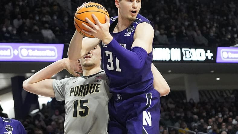 Feb 16, 2022; Evanston, Illinois, USA; Northwestern Wildcats forward Robbie Beran (31) grabs a rebound in front of Purdue Boilermakers center Zach Edey (15) during the first half at Welsh-Ryan Arena. Mandatory Credit: David Banks-USA TODAY Sports