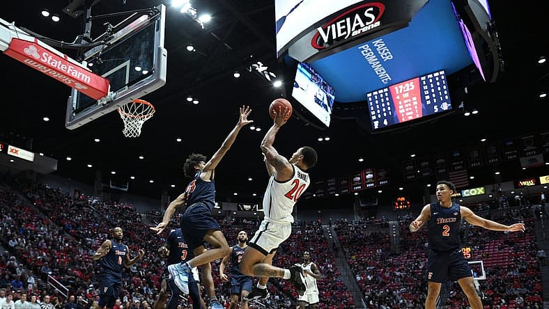 Nov 7, 2022; San Diego, California, USA; San Diego State Aztecs guard Matt Bradley (20) shoots the ball over Cal State Fullerton Titans guard Tory San Antonio (23) during the first half at Viejas Arena. Mandatory Credit: Orlando Ramirez-USA TODAY Sports