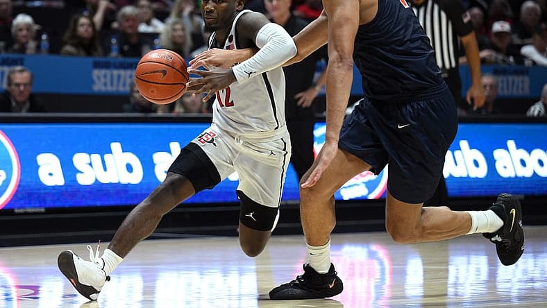 Nov 7, 2022; San Diego, California, USA; San Diego State Aztecs guard Darrion Trammell (12) dribbles the ball while defended by Cal State Fullerton Titans forward Vincent Lee (13) during the second half at Viejas Arena. Mandatory Credit: Orlando Ramirez-USA TODAY Sports