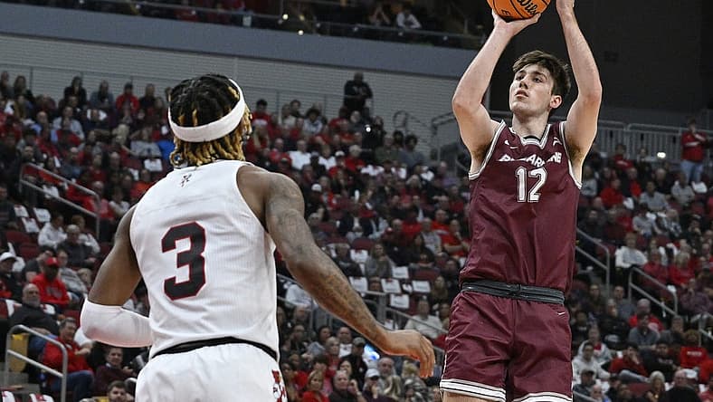 Nov 9, 2022; Louisville, Kentucky, USA; Bellarmine Knights forward Langdon Hatton (12) shoots against Louisville Cardinals guard El Ellis (3) during the first half at KFC Yum! Center. Mandatory Credit: Jamie Rhodes-USA TODAY Sports