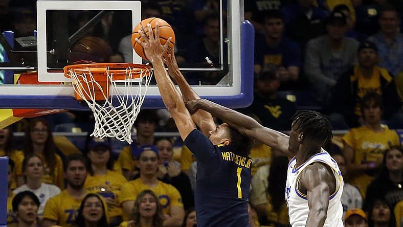Nov 11, 2022; Pittsburgh, Pennsylvania, USA; West Virginia Mountaineers forward Emmitt Matthews Jr. (1) dunks the ball past Pittsburgh Panthers center Federiko Federiko (right) during the first half at the Petersen Events Center. Mandatory Credit: Charles LeClaire-USA TODAY Sports