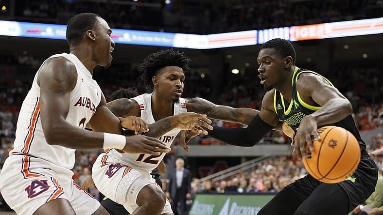 Nov 11, 2022; Auburn, Alabama, USA;  South Florida Bulls forward Keyshawn Bryant (23) loses control of the ball as Auburn Tigers guard Zep Jasper (12) and forward Chris Moore (5) apply pressure during the first half at Neville Arena. Mandatory Credit: John Reed-USA TODAY Sports