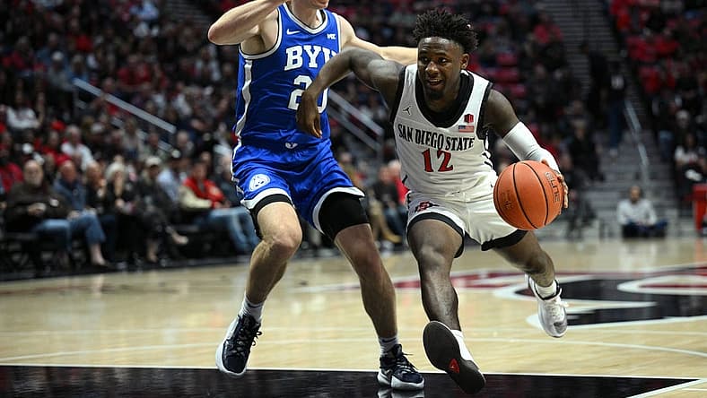 Nov 11, 2022; San Diego, California, USA; San Diego State Aztecs guard Darrion Trammell (12) dribbles the ball while defended by Brigham Young Cougars guard Spencer Johnson (20) during the first half at Viejas Arena. Mandatory Credit: Orlando Ramirez-USA TODAY Sports