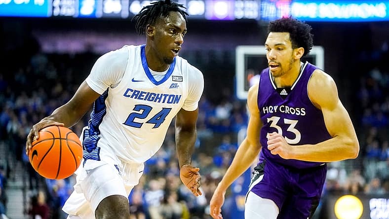 Nov 14, 2022; Omaha, Nebraska, USA; Creighton Bluejays forward Arthur Kaluma (24) drives to the hoop against Holy Cross Crusaders forward Caleb Kenney (33) during the first half at CHI Health Center Omaha. Mandatory Credit: Dylan Widger-USA TODAY Sports