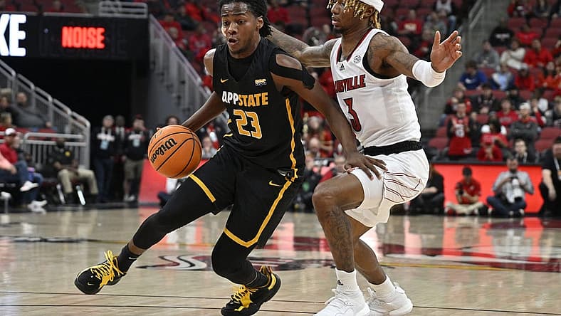 Nov 15, 2022; Louisville, Kentucky, USA;  Appalachian State Mountaineers guard Terence Harcum (23) dribbles against Louisville Cardinals guard El Ellis (3) during the first half at KFC Yum! Center. Mandatory Credit: Jamie Rhodes-USA TODAY Sports