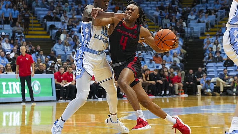 Nov 15, 2022; Chapel Hill, North Carolina, USA; Gardner Webb Runnin Bulldogs guard DQ Nicholas (4) tries too take the ball past North Carolina Tar Heels guard D'Marco Dunn (11) during the first half at Dean E. Smith Center. Mandatory Credit: James Guillory-USA TODAY Sports