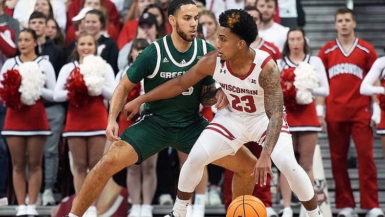 Nov 15, 2022; Madison, Wisconsin, USA; Wisconsin Badgers guard Chucky Hepburn (23) dribbles under coverage by Green Bay Phoenix guard Nate Jenkins (55) during the first half at the Kohl Center. Mandatory Credit: Kayla Wolf-USA TODAY Sports