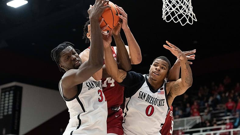 Nov 15, 2022; Stanford, California, USA; San Diego State Aztecs forwards Nathan Mensah (31) and Keshad Johnson (0) fight for the ball against Stanford Cardinal forward Spencer Jones (14) during the second half at Maples Pavilion. Mandatory Credit: Stan Szeto-USA TODAY Sports