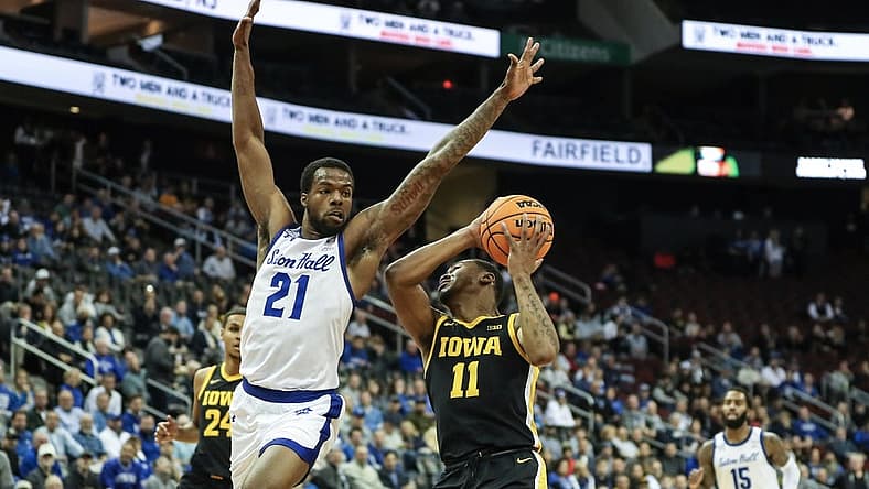 Nov 16, 2022; Newark, New Jersey, USA; Iowa Hawkeyes guard Tony Perkins (11) attempts to drive past Seton Hall Pirates guard Femi Odukale (21) in the first half at Prudential Center. Mandatory Credit: Wendell Cruz-USA TODAY Sports