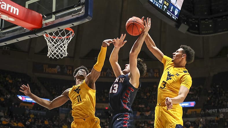 Nov 18, 2022; Morgantown, West Virginia, USA; West Virginia Mountaineers forward Tre Mitchell (3) blocks a shot from Pennsylvania Quakers forward Nick Spinoso (13) during the first half at WVU Coliseum. Mandatory Credit: Ben Queen-USA TODAY Sports