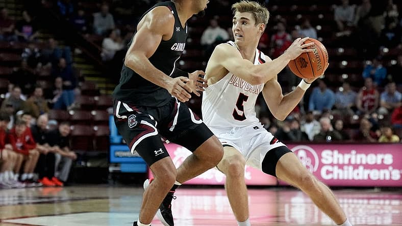 Nov 18, 2022; Charleston, South Carolina, USA; Davidson Wildcats guard Grant Huffman (5) drives around South Carolina Gamecocks guard Jacobi Wright (1) in the first half at TD Arena. Mandatory Credit: David Yeazell-USA TODAY Sports
