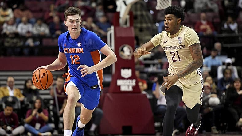 Nov 18, 2022; Tallahassee, Florida, USA; Florida Gators forward Colin Castleton (12) drives up the court past Florida State Seminoles guard Cam'Ron Fletcher (21) during the second half at Donald L. Tucker Center. Mandatory Credit: Melina Myers-USA TODAY Sports