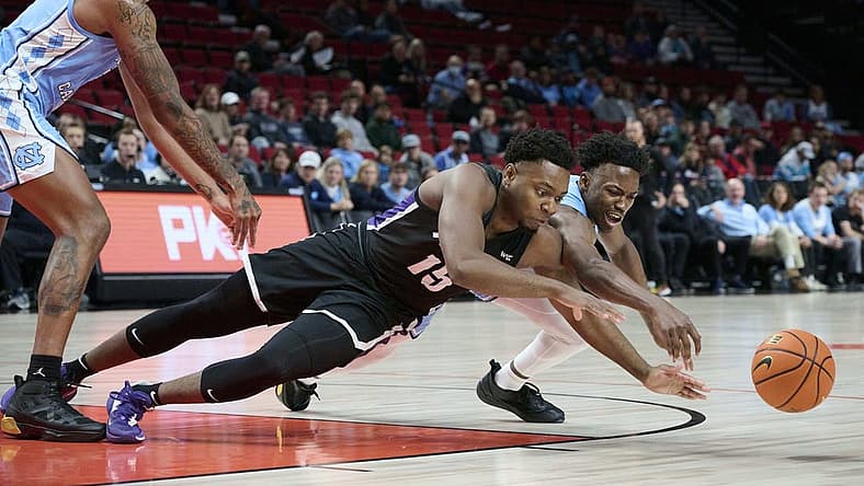 Nov 24, 2022; Portland, Oregon, USA; Portland Pilots forward Chika Nduka (15) and North Carolina Tar Heels guard D'Marco Dunn (11) dive for the ball during the first half at Moda Center. Mandatory Credit: Troy Wayrynen-USA TODAY Sports