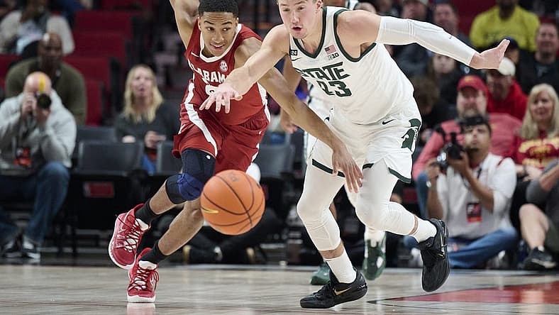 Nov 24, 2022; Portland, Oregon, USA; Alabama Crimson Tide guard Nimari Burnett (25) and Michigan State Spartans guard Jason Whitens (43) race after the basketball during the first half at Moda Center. Mandatory Credit: Troy Wayrynen-USA TODAY Sports
