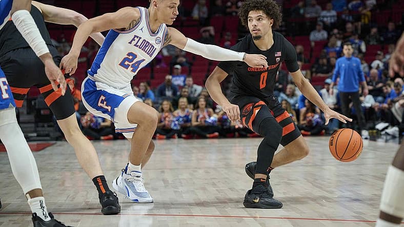 Nov 25, 2022; Portland, Oregon, USA; Oregon State Beavers guard Jordan Pope (0) dribbles the ball during the second half against Florida Gators guard Riley Kugel (24) at Moda Center. Mandatory Credit: Troy Wayrynen-USA TODAY Sports