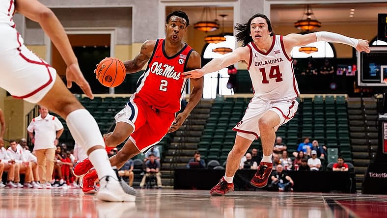 Nov 27, 2022; Orlando, FL, USA; Mississippi Rebels guard TJ Caldwell (2) dribbles past Oklahoma Sooners guard Bijan Cortes (14) during the first half at ESPN Wide World of Sports. Mandatory Credit: Rich Storry-USA TODAY Sports