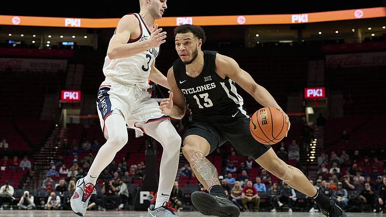 Nov 27, 2022; Portland, Oregon, USA; Iowa State Cyclones guard Jaren Holmes (13) drives to the basket during the second half against Connecticut Huskies guard Joey Calcaterra (3) at Moda Center. The Huskies won the Phil Knight Invitational Basketball Tournament 71-53. Mandatory Credit: Troy Wayrynen-USA TODAY Sports