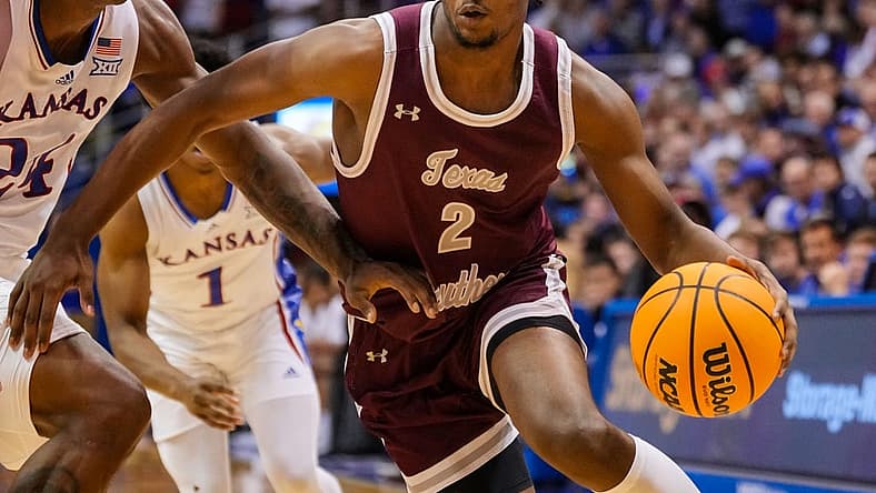 Nov 28, 2022; Lawrence, Kansas, USA; Texas Southern Tigers forward Davon Barnes (2) drives against Kansas Jayhawks forward K.J. Adams Jr. (24) during the first half at Allen Fieldhouse. Mandatory Credit: Jay Biggerstaff-USA TODAY Sports