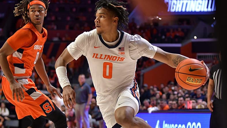 Nov 29, 2022; Champaign, Illinois, USA; Illinois Fighting Illini guard Terrence Shannon Jr. (0) drives the ball past Syracuse Orange forward Chris Bell (0) during the first half at State Farm Center. Mandatory Credit: Ron Johnson-USA TODAY Sports
