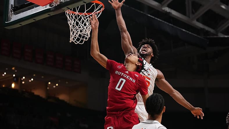 Nov 30, 2022; Coral Gables, Florida, USA; Miami Hurricanes forward Norchad Omier (15) blocks the shot of Rutgers Scarlet Knights guard Derek Simpson (0) during the first half at Watsco Center. Mandatory Credit: Jasen Vinlove-USA TODAY Sports