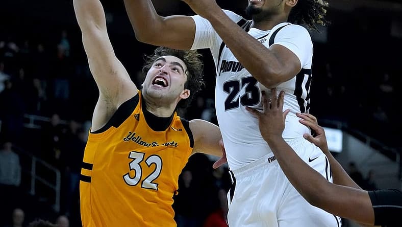 Providence shooter Bryce Hopkins drives in for a lay up over AIC defender Buka Peikrishvili.