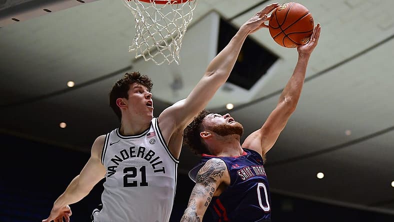 Nov 23, 2022; Anaheim, California, USA; Vanderbilt Commodores forward Liam Robbins (21) blocks the shot of St. Mary's Gaels guard Logan Johnson (0) during the first half at Anaheim Convention Center. Mandatory Credit: Gary A. Vasquez-USA TODAY Sports