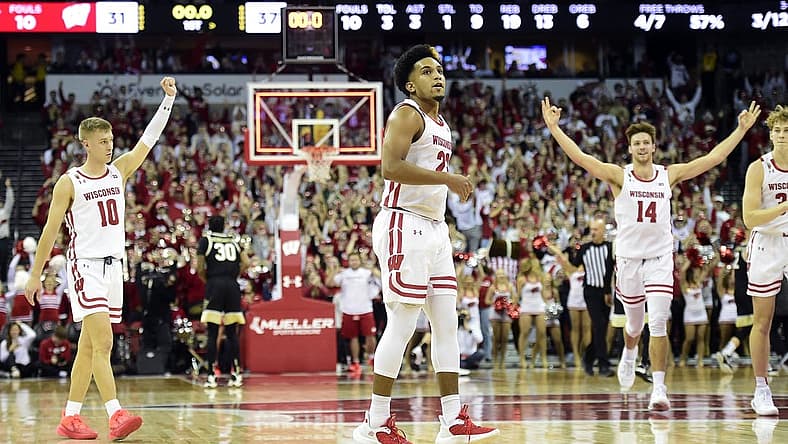 Nov 29, 2022; Madison, Wisconsin, USA; Wisconsin Badgers guard Chucky Hepburn (23) looks on as teammates Isaac Lindsey (10) and Carter Gilmore (14) celebrate his buzzer-beating shot at the end of the first half at the Kohl Center. Mandatory Credit: Kayla Wolf-USA TODAY Sports