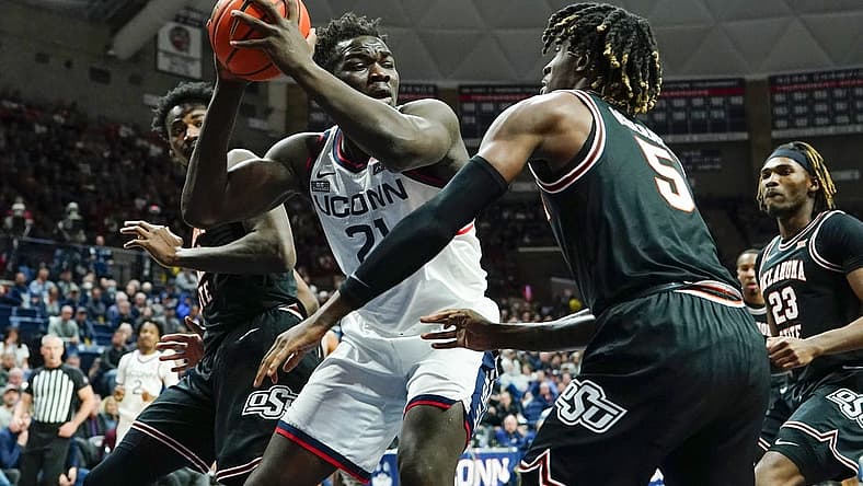 Dec 1, 2022; Storrs, Connecticut, USA; Connecticut Huskies forward Adama Sanogo (21) controls the ball against Oklahoma State Cowboys guard Caleb Asberry (5) during the first half at Harry A. Gampel Pavilion. Mandatory Credit: Gregory Fisher-USA TODAY Sports