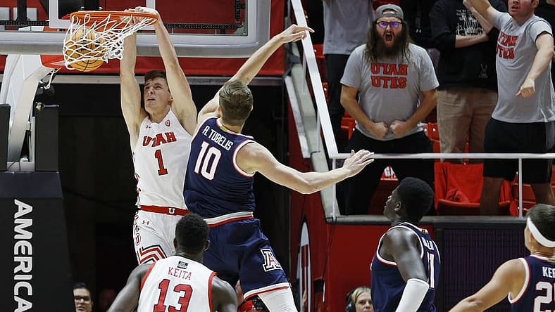 Dec 1, 2022; Salt Lake City, Utah, USA; Utah Utes forward Ben Carlson (1) dunks against Arizona Wildcats forward Azuolas Tubelis (10) in the first half at Jon M. Huntsman Center. Mandatory Credit: Jeffrey Swinger-USA TODAY Sports