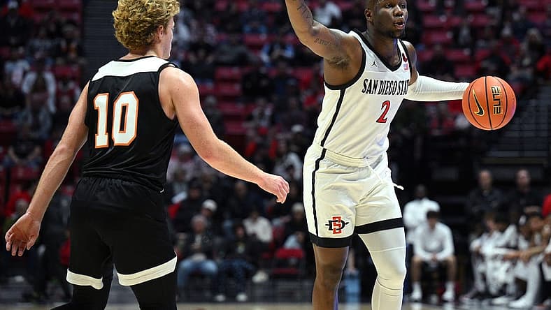 Dec 2, 2022; San Diego, California, USA; San Diego State Aztecs guard Adam Seiko (2) gestures while dribbling the ball as Occidental Tigers guard Aiden Williams (10) defends during the first half at Viejas Arena. Mandatory Credit: Orlando Ramirez-USA TODAY Sports